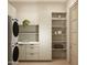 Bright laundry room with stacked washer/dryer, storage cabinets, shelving, and a folding counter at 7445 E Vista Dr, Scottsdale, AZ 85250