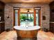 Elegant bathroom showcasing a freestanding tub, brick accent wall, and vanity with custom cabinetry at 8022 N Ironwood Dr, Paradise Valley, AZ 85253