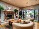 Cozy living room with a stone fireplace, comfortable seating, and doors to an outdoor space at 8022 N Ironwood Dr, Paradise Valley, AZ 85253