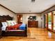 Spacious main bedroom featuring wood floors, brick accent wall, and access to the yard through glass doors at 8022 N Ironwood Dr, Paradise Valley, AZ 85253