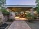 Covered patio area featuring brick pillars, a patterned stone wall, and cozy outdoor dining space at 8022 N Ironwood Dr, Paradise Valley, AZ 85253