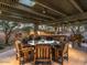 Spacious covered patio with a large round table, ample seating, and a built-in bar area at 8022 N Ironwood Dr, Paradise Valley, AZ 85253