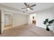 A bedroom space that includes a fan, bathroom access, and an adjacent hallway at 850 S River Dr # 1047, Tempe, AZ 85281