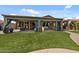 View of a covered patio with lights and outdoor furniture, next to a green manicured lawn at 10033 W Jessie Ln, Peoria, AZ 85383