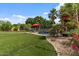 Backyard pool surrounded by lush landscaping, palm trees, and a cozy pergola creating a private retreat at 10033 W Jessie Ln, Peoria, AZ 85383