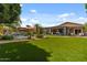 Spacious backyard with artificial turf, a pool, mature trees, and a covered patio, perfect for outdoor entertaining at 10033 W Jessie Ln, Peoria, AZ 85383