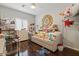 Bright bedroom with hardwood floors, a daybed with plush toys, and a charming, decorative mirror at 10033 W Jessie Ln, Peoria, AZ 85383