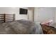 Comfortable bedroom featuring a soft chair, a modern TV, and closet doors for ample storage at 10033 W Jessie Ln, Peoria, AZ 85383