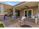 Stylish covered patio featuring stone accents, brick flooring, and comfortable seating area, perfect for outdoor relaxation at 10033 W Jessie Ln, Peoria, AZ 85383