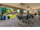 Spacious covered patio with dining area, ceiling fans, brick flooring and views of a beautifully landscaped backyard at 10033 W Jessie Ln, Peoria, AZ 85383