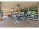 Relaxing covered patio with ceiling fans, brick flooring, and multiple seating areas for entertaining guests at 10033 W Jessie Ln, Peoria, AZ 85383