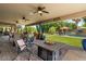 Inviting covered patio with fire pit, ceiling fans, and views of the backyard oasis with pool and lush landscaping at 10033 W Jessie Ln, Peoria, AZ 85383
