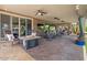 Expansive covered patio featuring a fire pit, ceiling fans, outdoor seating, and seamless indoor-outdoor flow at 10033 W Jessie Ln, Peoria, AZ 85383