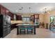 Kitchen island with dark wood cabinets, granite countertop, and stainless steel appliances at 10033 W Jessie Ln, Peoria, AZ 85383