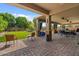 Spacious covered patio featuring comfortable seating, lush landscaping, and a well-manicured backyard at 10033 W Jessie Ln, Peoria, AZ 85383
