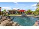 Beautiful backyard pool with a volleyball net, rock features, and an outdoor living space at 10033 W Jessie Ln, Peoria, AZ 85383