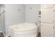 Bright bathroom featuring a corner bathtub with a silver faucet, white cabinets, and snowflake decorations at 11192 N Johnson Rd, Maricopa, AZ 85139