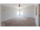 Bright bedroom with soft carpet, ceiling fan, and a large window at 11192 N Johnson Rd, Maricopa, AZ 85139