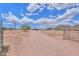 Gated driveway leading to a single story home, surrounded by a desert landscape and mountain views at 11192 N Johnson Rd, Maricopa, AZ 85139