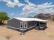 Exterior view of home with gray paint, white trim, and mountain views in the background at 11192 N Johnson Rd, Maricopa, AZ 85139
