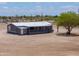 Charming gray home featuring a covered front porch and a well maintained desert landscape at 11192 N Johnson Rd, Maricopa, AZ 85139