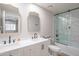 Updated bathroom featuring double vanity, stylish mirrors, and shower with glass enclosure at 11333 N 92Nd St # 1075, Scottsdale, AZ 85260