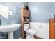 Powder bathroom featuring blue walls, a pedestal sink, and a mirror at 1145 E Harold Dr, San Tan Valley, AZ 85140