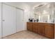 Bathroom featuring dual sinks, wood cabinets, and vanity mirrors at 1145 E Harold Dr, San Tan Valley, AZ 85140