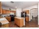 This kitchen features an island, wood cabinets, recessed lights and black appliances at 1145 E Harold Dr, San Tan Valley, AZ 85140