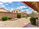 View of the backyard featuring desert landscaping, block fence, and covered patio at 11524 W Rosewood Dr, Avondale, AZ 85392