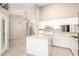 Open kitchen area featuring white cabinetry, an island, and a view to an open living area at 11524 W Rosewood Dr, Avondale, AZ 85392