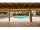 A covered patio provides views of the sparkling pool and beautifully landscaped backyard at 12448 N 76Th St, Scottsdale, AZ 85260