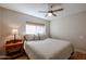 Bright bedroom featuring a ceiling fan, neutral walls, and a comfortable queen-size bed at 12448 N 76Th St, Scottsdale, AZ 85260