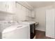 Laundry room with white washer, dryer, cabinets, and laminate flooring at 12835 N 16Th Dr, Phoenix, AZ 85029