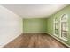 Bright and airy room featuring hardwood floors, green accent wall, and arched windows at 12835 N 16Th Dr, Phoenix, AZ 85029