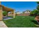 Expansive backyard boasts a large covered patio and verdant green grass at 12950 W Alegre Dr, Litchfield Park, AZ 85340