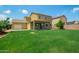 Spacious backyard features lush green grass, a covered patio, and a detached two-car garage at 12950 W Alegre Dr, Litchfield Park, AZ 85340