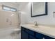 Bathroom features a shower-tub combo, white tile flooring, and a blue vanity with a white sink at 12950 W Alegre Dr, Litchfield Park, AZ 85340