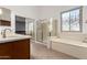 Bright bathroom showcasing double sinks, soaking tub, and tiled shower at 12950 W Alegre Dr, Litchfield Park, AZ 85340