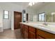 Bathroom featuring wood cabinets, double sinks, and tiled floor at 12950 W Alegre Dr, Litchfield Park, AZ 85340