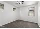 Sunny bedroom featuring carpet, ceiling fan, and three windows at 12950 W Alegre Dr, Litchfield Park, AZ 85340
