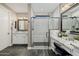 Modern bathroom featuring a glass shower, dual sink vanity with granite countertop and stylish lighting fixtures at 13252 W Steed Ridge Rd, Peoria, AZ 85383