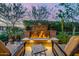 Outdoor fire pit feature in the backyard with two chairs, desert landscape, and a mosaic tiled table at 13252 W Steed Ridge Rd, Peoria, AZ 85383