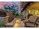Relaxing covered patio with outdoor seating, a tranquil water feature, and lush desert landscaping at 13252 W Steed Ridge Rd, Peoria, AZ 85383