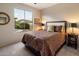 Bright bedroom with a comfortable bed, neutral walls, and a view of the backyard pool through a large window at 13634 W San Miguel Ave, Litchfield Park, AZ 85340