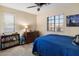 Bedroom with beige carpet, a ceiling fan, and a window providing natural light, furnished with a bed and dresser at 13634 W San Miguel Ave, Litchfield Park, AZ 85340