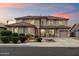 Beautiful two-story home boasts a neutral color, tile roof, well-maintained lawn, and attached two-car garage at 13634 W San Miguel Ave, Litchfield Park, AZ 85340