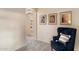 Bright hallway with a comfortable blue chair and decorative artwork leads to other rooms in the home at 13634 W San Miguel Ave, Litchfield Park, AZ 85340