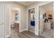 Hallway with wood floors leading to a bathroom, bedroom with a blue bed, and a home office at 13634 W San Miguel Ave, Litchfield Park, AZ 85340