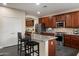 Modern kitchen features dark wood cabinetry, stainless steel appliances, granite countertops and mosaic backsplash at 13634 W San Miguel Ave, Litchfield Park, AZ 85340